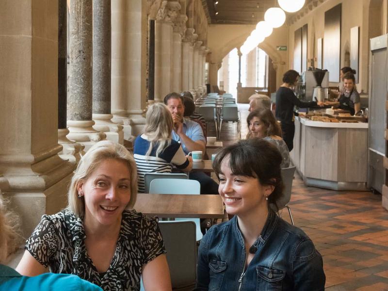 A view of the cafe where visitors are eating and drinking and someone is paying for food at the till