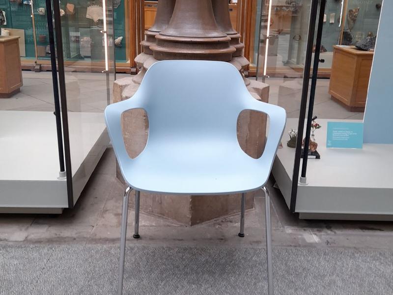 A blue chair in front of a pillar in the Main Court