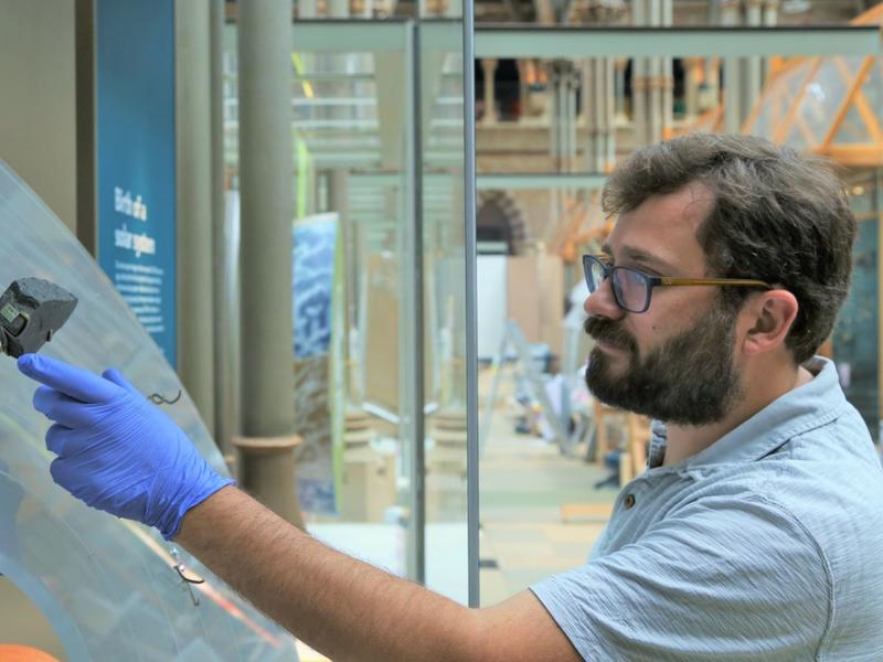 A museum staff member placing specimens into a redisplay case
