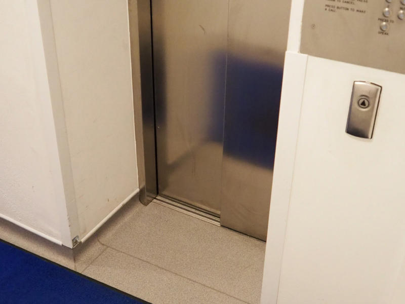 The entrance to the lift which has metal doors and a button panel on the right hand side
