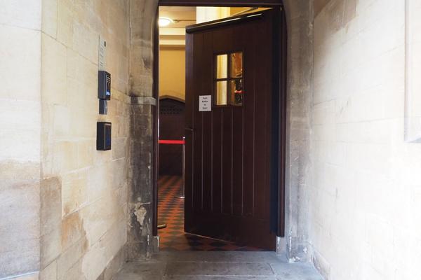 The wooden door to the accessible entrance which can be opened with a push button on the left hand side.