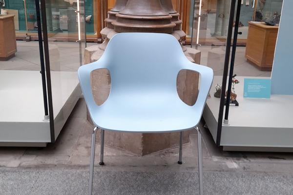 A blue chair in front of a pillar in the Main Court