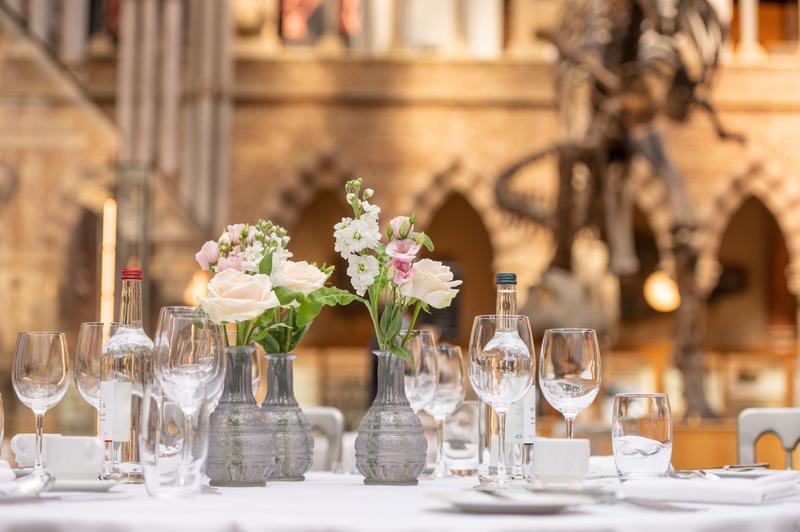 A table set with a pink bouquet and wine glasses