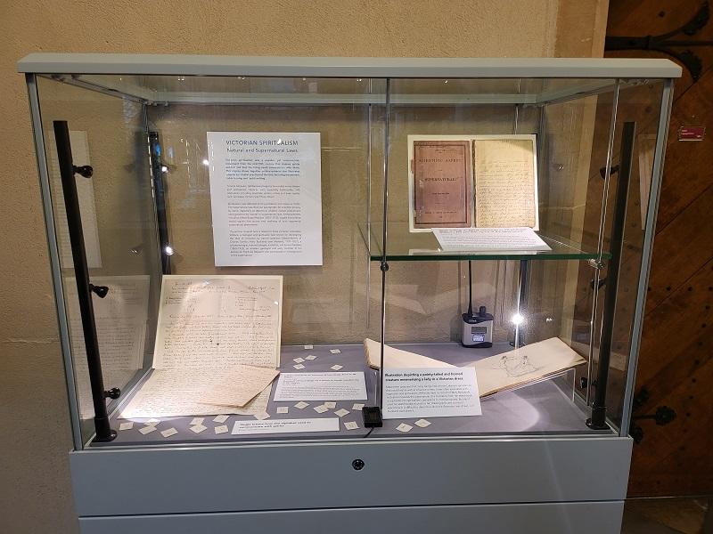 Image of small exhibition case containing archival letters and drawings
