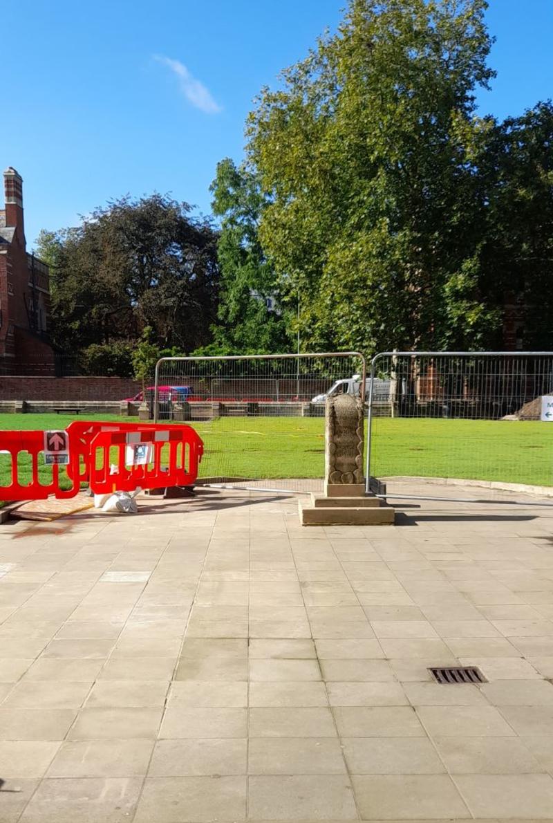 Leaving the Museum through the front doors, you will see a paved area with a sculpture, and a lawn behind which is currently barriered off